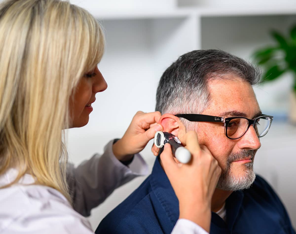 Medical provider looking into a man's ear