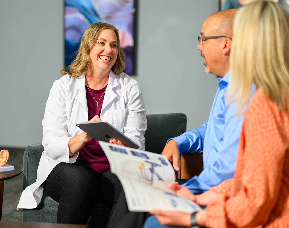 Healthcare professional talking with patient and their companion.