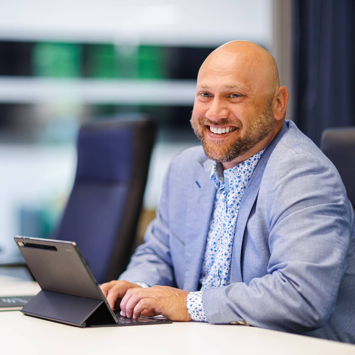 A male professional typing on his ipad