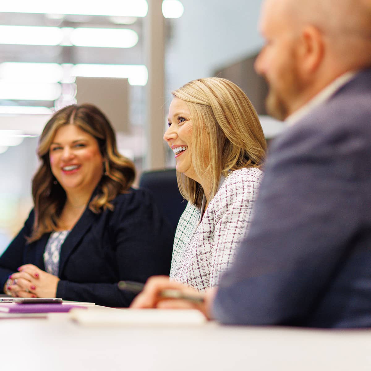 Three professional people speaking at a conference table